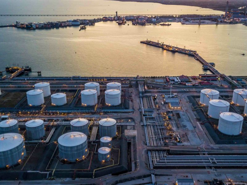 Aerial view storage tank farm at night, Tank farm storage chemical petroleum petrochemical refinery product at oil terminal, Business commercial trade fuel and energy transport by tanker vessel.