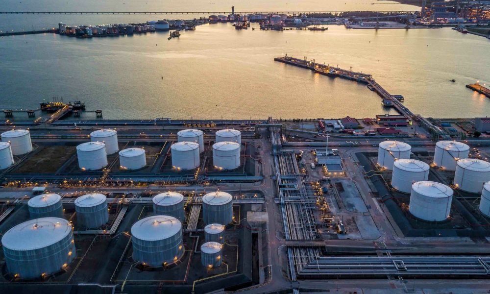 Aerial view storage tank farm at night, Tank farm storage chemical petroleum petrochemical refinery product at oil terminal, Business commercial trade fuel and energy transport by tanker vessel.